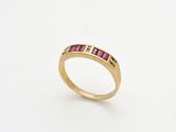 une bague en or sertie de pierres roses sur fond blanc