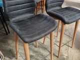 une paire de chaises grises à pieds en bois dans un entrepôt
