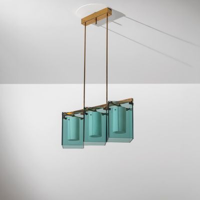 a pair of blue glass hanging lights hanging from a ceiling