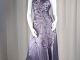 mannequin dressed in a purple dress on display in front of a curtain