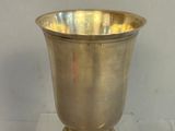 a silver vase that is on a clear base