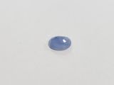 an oval blue sapphire stone on a white surface