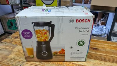 une boîte contenant un mixeur, posée sur une table en bois