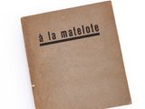 un livre ouvert, sur lequel figurent des caractères noirs, posé sur une surface blanche