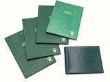 four green passport cases sitting on top of each other on a white surface