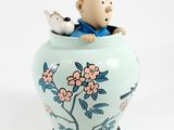 a small figurine of a man sitting in a vase