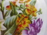 a white vase with colorful flowers painted on it