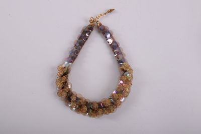 a close up of a beaded necklace on a white surface