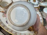 a person holding a plate with a tea pot on it