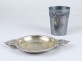 une assiette en argent et une tasse en argent posées sur une table blanche