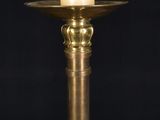 a close up of a gold candle holder with a white rose on it
