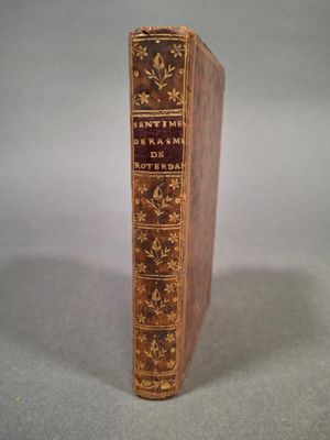 un vieux livre posé sur une table à côté d'une table blanche