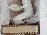 a white mannequin sitting inside of a cardboard box