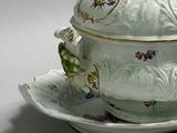 a bowl and saucer on a plate on a white surface