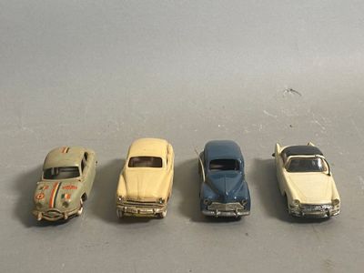 four toy cars are lined up in a row on a table