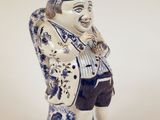 une figurine bleue et blanche représentant un homme coiffé d'un chapeau