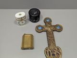 a cross, a lighter, and other items that are on a table