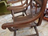 four wooden chairs sitting in a room with a fireplace in the background