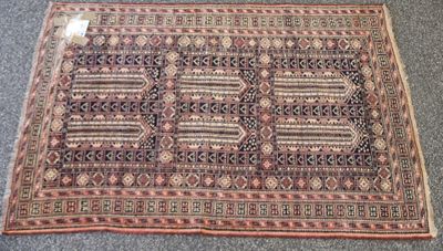 un vieux tapis posé par terre, sur lequel est accrochée une étiquette