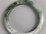an image of a green jade bangle on a white surface