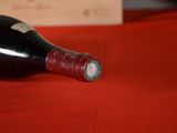 a bottle of wine sitting on a red table cloth