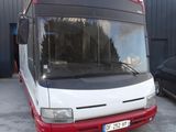a red and white bus parked in front of a building
