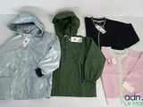 Plusieurs vestes sont alignées sur une surface blanche