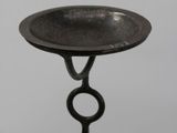 a black candle holder on a stand with a ring on it