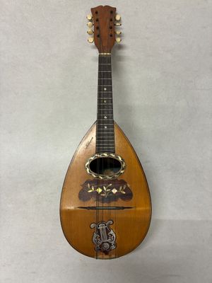une vieille guitare en bois accrochée à un mur sur fond blanc