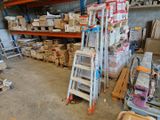 une échelle posée dans une pièce, sur laquelle sont empilés de nombreux cartons
