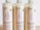 three bottles of body lotion sitting on top of a wooden table