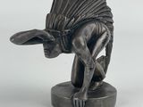 statue of a winged animal with a feathered head on a base
