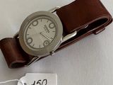 a wrist watch with a brown leather band and a price tag