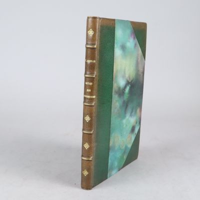 un vieux livre posé sur une table blanche à côté d'un mur blanc