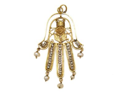 un gros plan d'un pendentif hamsa en or et perles sur fond blanc