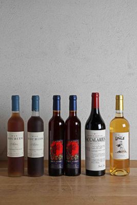 plusieurs bouteilles de vin sont alignées sur une table en bois