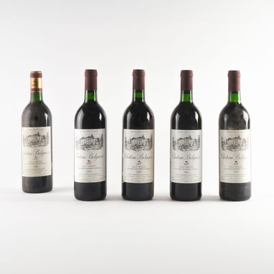 quatre bouteilles de vin sont alignées sur une surface blanche
