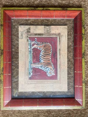painting of a tiger in a red frame on a wall
