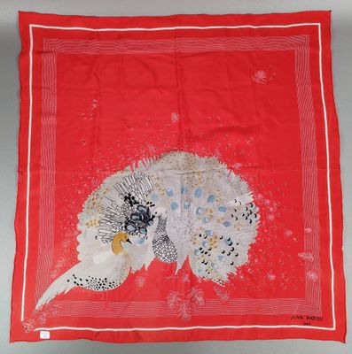 une écharpe rouge sur laquelle est représenté un oiseau blanc et noir