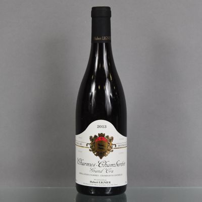 the bottle of wine is sitting on a glass table
