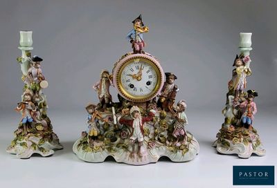 trois figurines surmontées d'une horloge