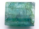 un gros plan d'une pierre verte sur une surface blanche