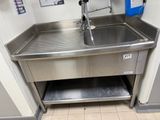 a stainless steel sink with a faucet in the corner