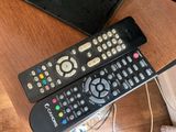 two remote controls sitting on a table next to a laptop