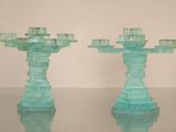 two glass candlesticks sitting on a glass table