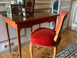 une chaise rouge placée devant un bureau sur lequel se trouve un miroir