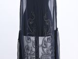 a black dress on a mannequin stand with a white background