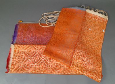 deux morceaux de tissu orange et violet posés sur une surface grise