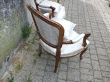 une chaise posée sur le trottoir, contre un mur