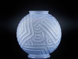 un vase blanc orné d'un motif sur un fond noir